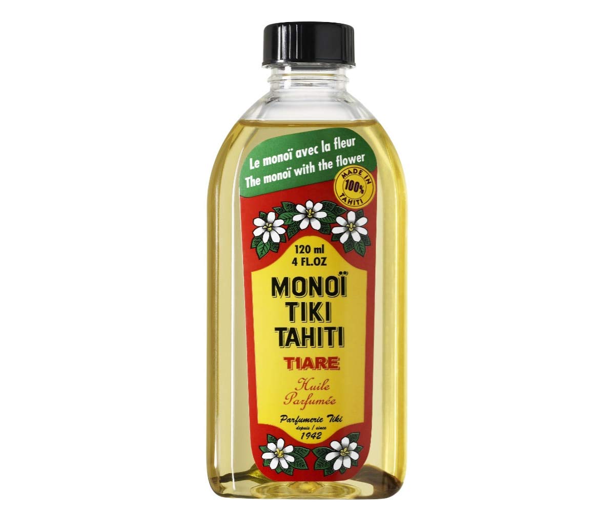 Monoi Tiki Tahiti coconut oil bottle pouring for skin and hair nourishment.