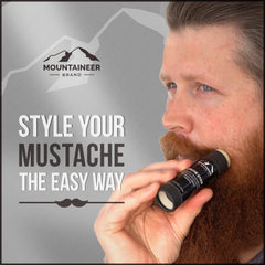 Mountaineer Brand Stache Stick being applied with fingers to shape a handlebar.