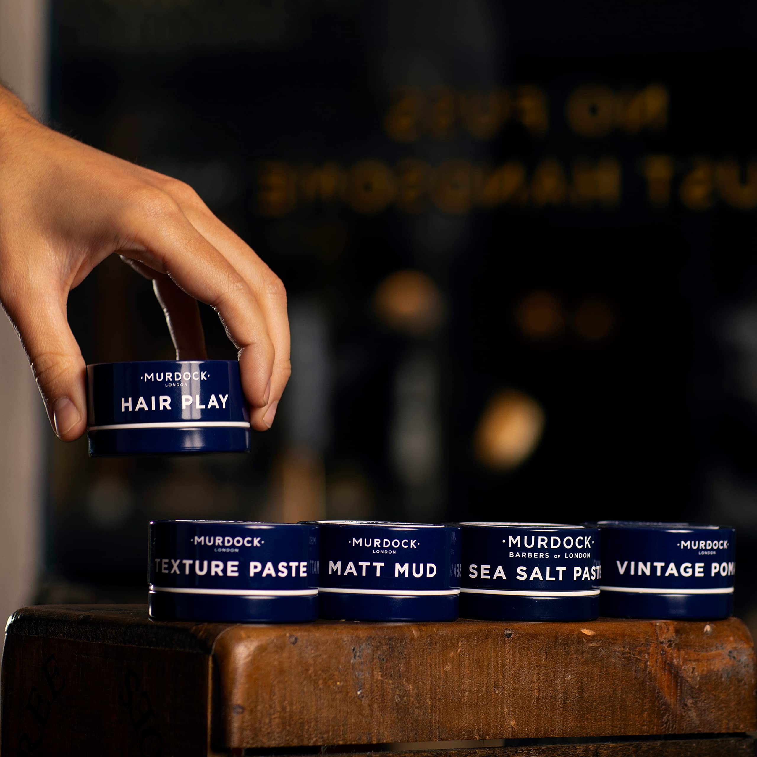 Hands applying Murdock London Texture Paste to hair for texture and shape.