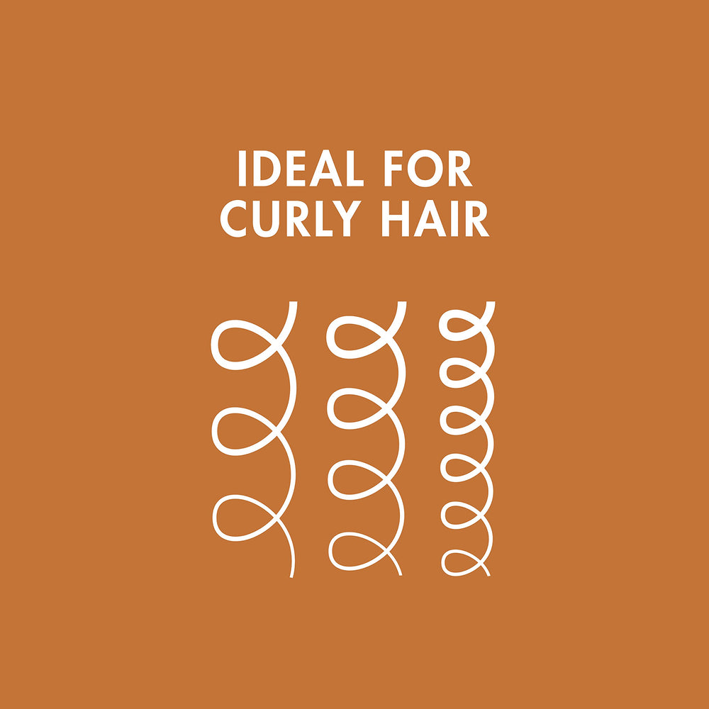 Nexxus Curl Define applying the leave-in to damp curls for frizz control.
