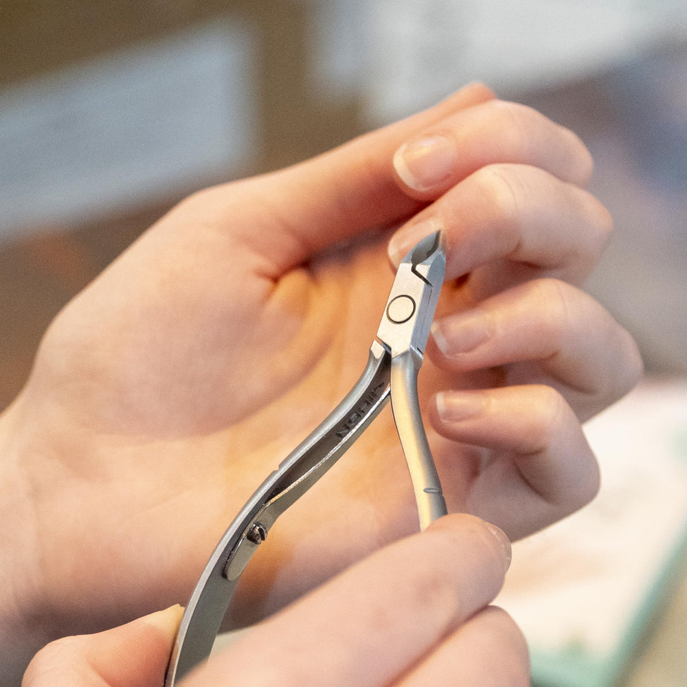 Nghia Cuticle Nipper D-04 hand-use photo showing ergonomic grip and control.