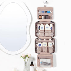 NISHEL travel toiletry bag hanging open showing four compartments for organized packing