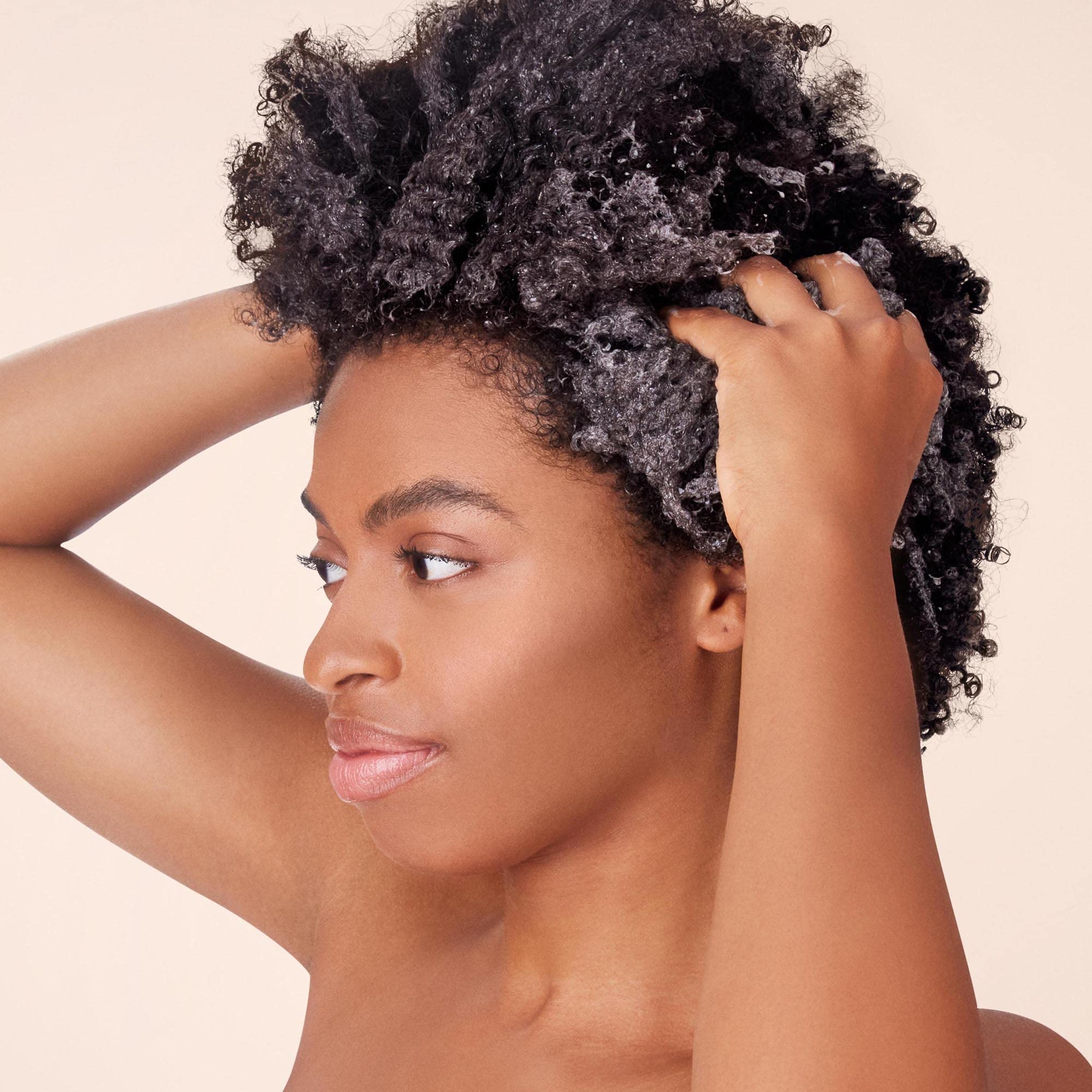 Not Your Mother's Naturals curl-definition shampoo applied to curly hair for hydration
