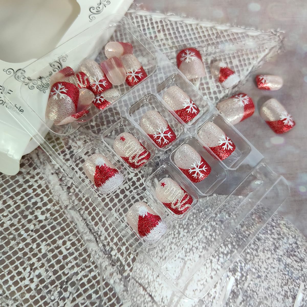 OSTTMA christmas press-on nails on a hand display for fast holiday glamour.
