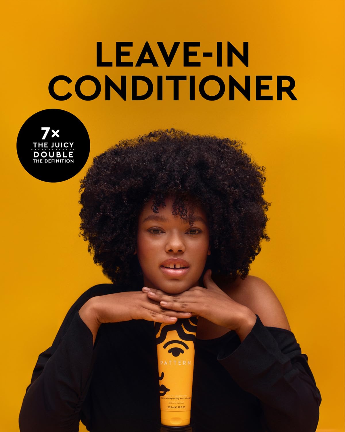 Close-up of PATTERN Beauty Leave-In Conditioner on defined curly hair.