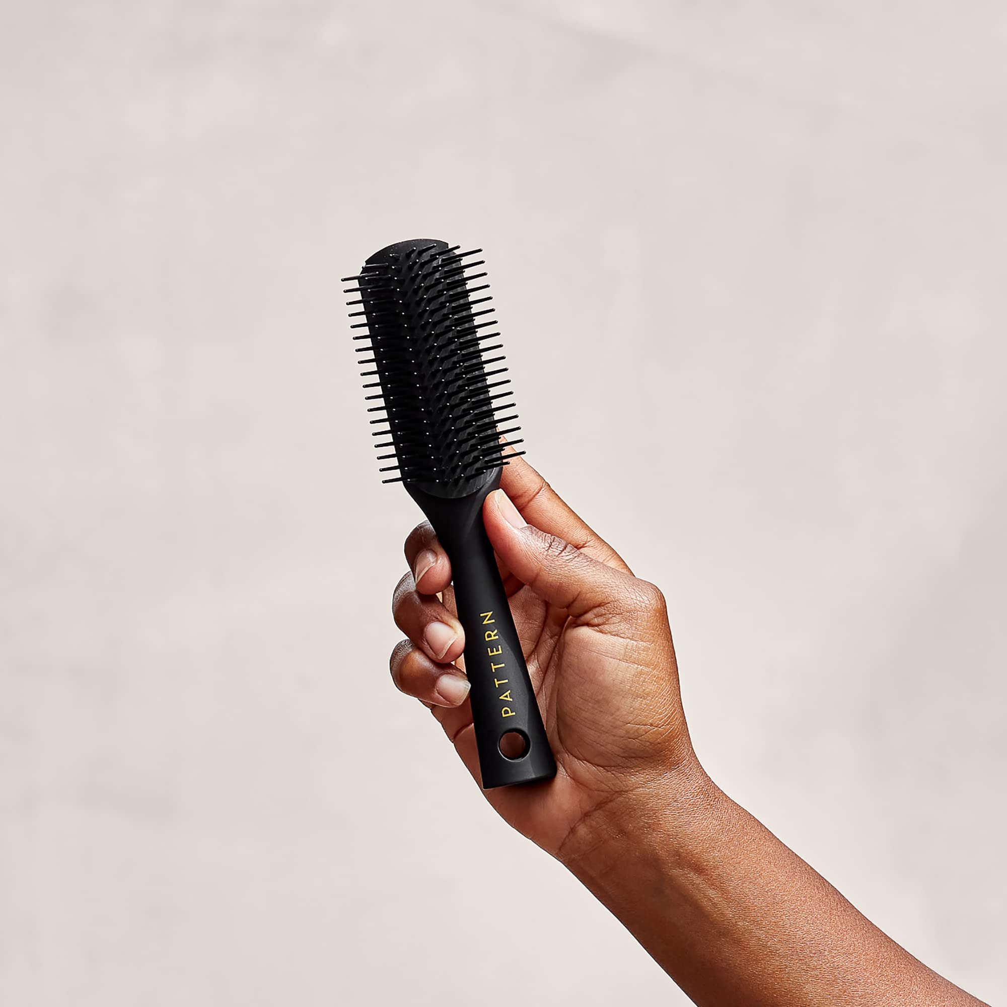 PATTERN Beauty Mini Shower Brush travel size in bag for on-the-go routines.