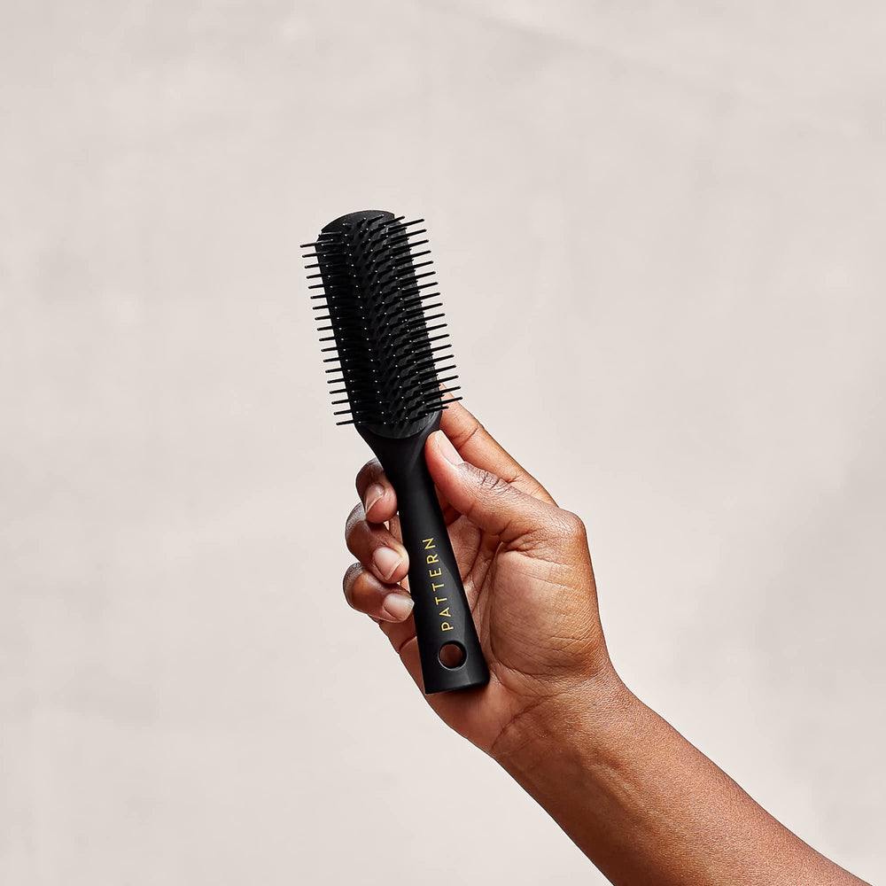 PATTERN Beauty Mini Shower Brush travel size in bag for on-the-go routines.