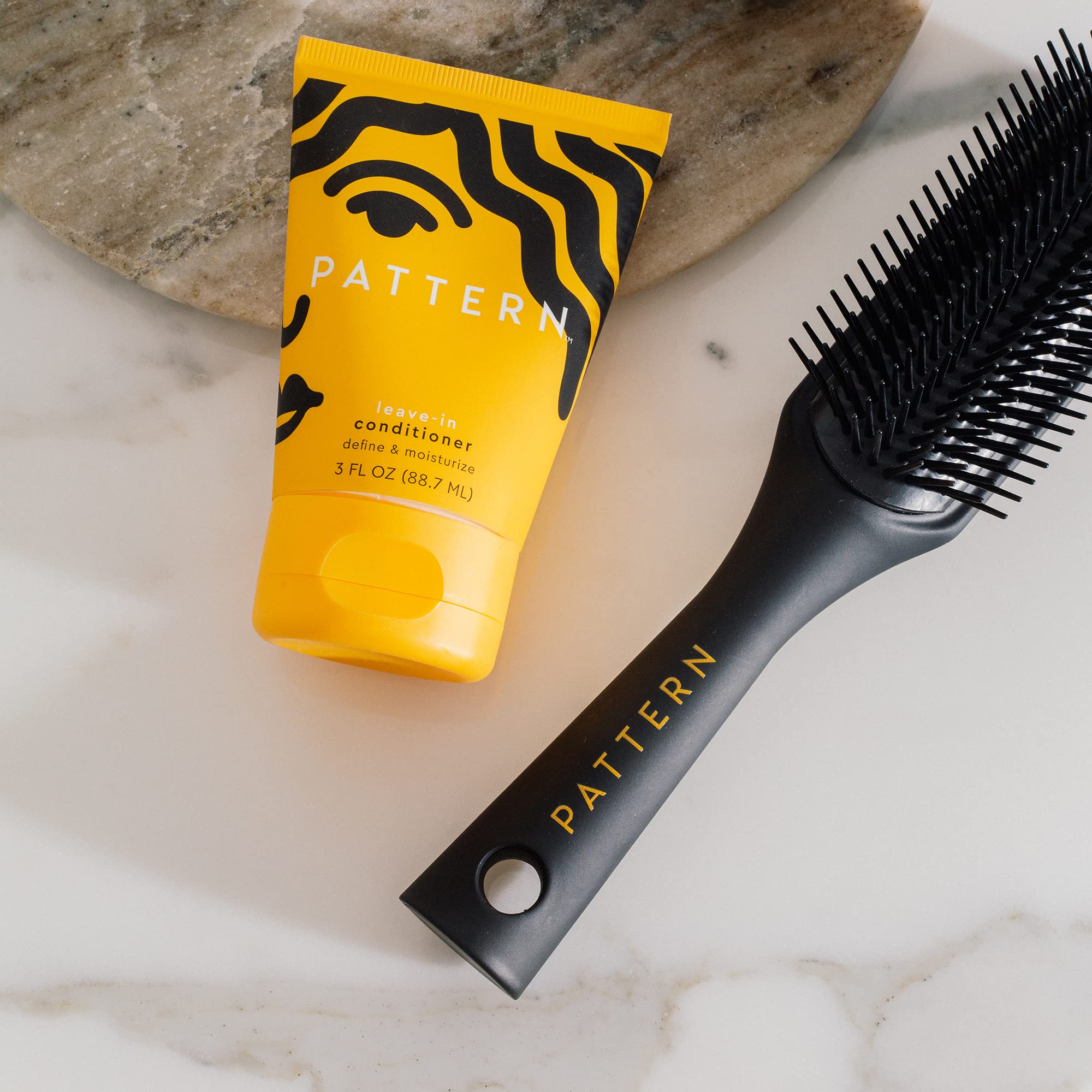 PATTERN Leave-In Conditioner shown with curly hair styling products.