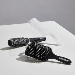 Paul Mitchell Pro Tools 427 Paddle Brush side view in use promotes volume during blow-dry