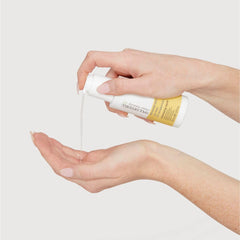 Paul Mitchell Volumizing Liquid being applied by hands for easy volume.