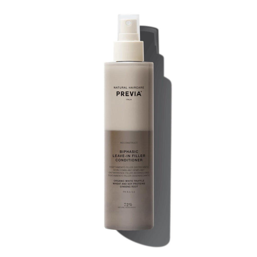 PREVIA Hydrating Biphasic Leave-In Spray bottle on shelf for frizz control and detangling.