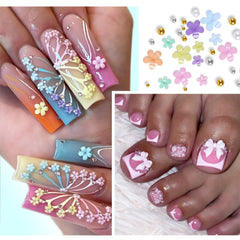 Qdsuh nail charms closeup showing metal beads and flatback flowers.