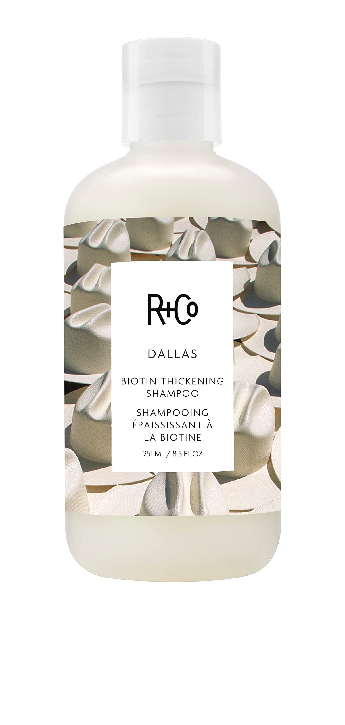 R+Co Dallas Thickening Shampoo bottle close-up highlights volumizing care for fine hair.
