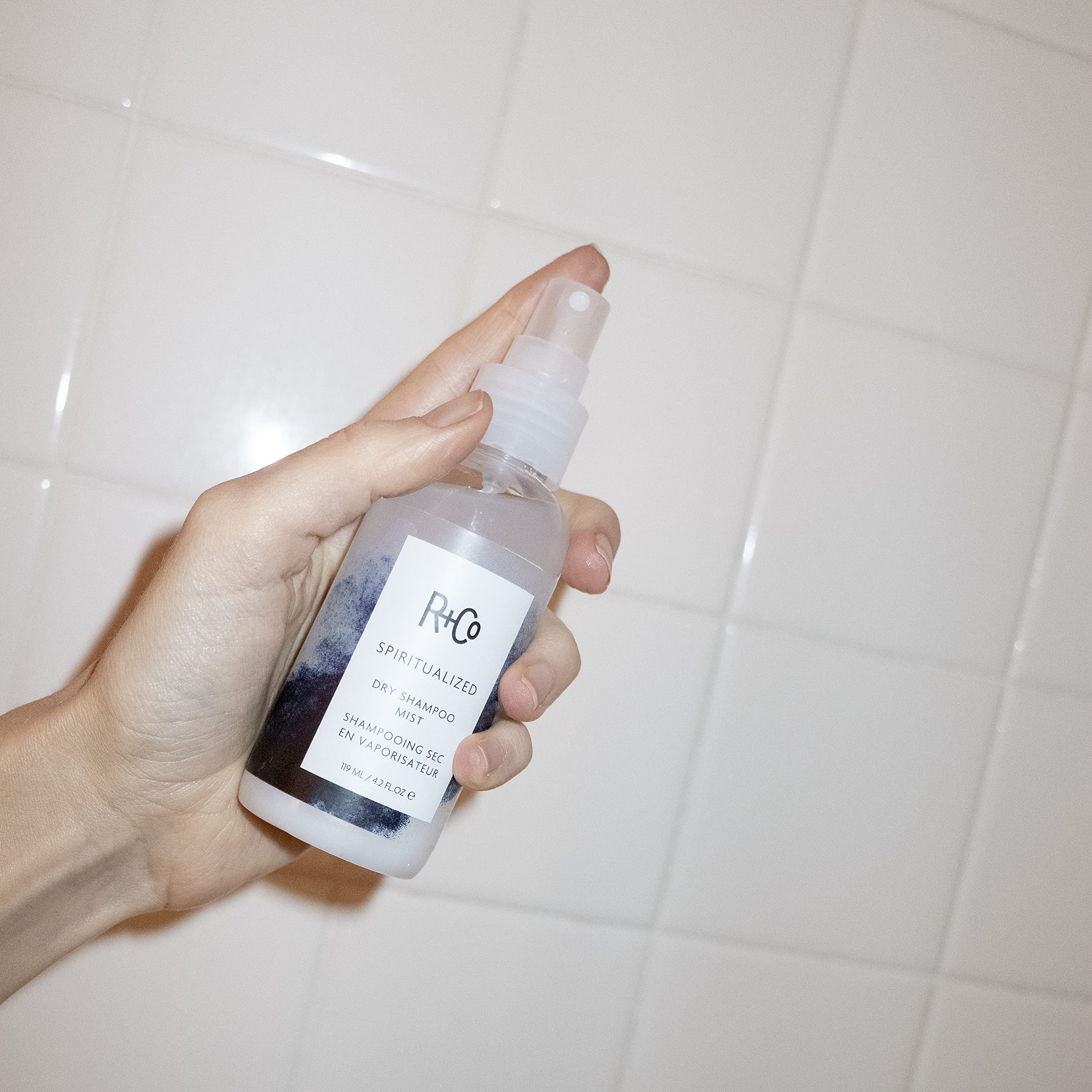 R+Co Spiritualized Dry Shampoo Mist applied to roots for quick refresh.