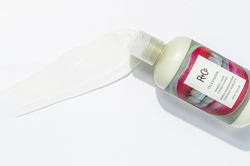 R+Co Television conditioner close-up on hair adds shine and moisture after wash.