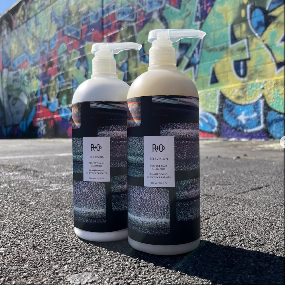 R+Co Television Perfect Hair Shampoo on sink with clean styling area.