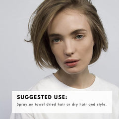 Hands applying R+Co Trophy Shine + Texture Spray for natural volume