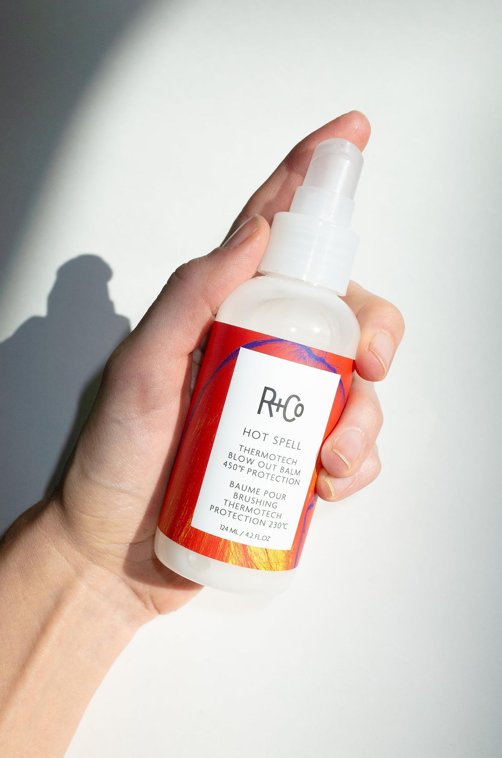 R+Co Hot Spell Thermotech Balm hair application demonstrates frizz control.