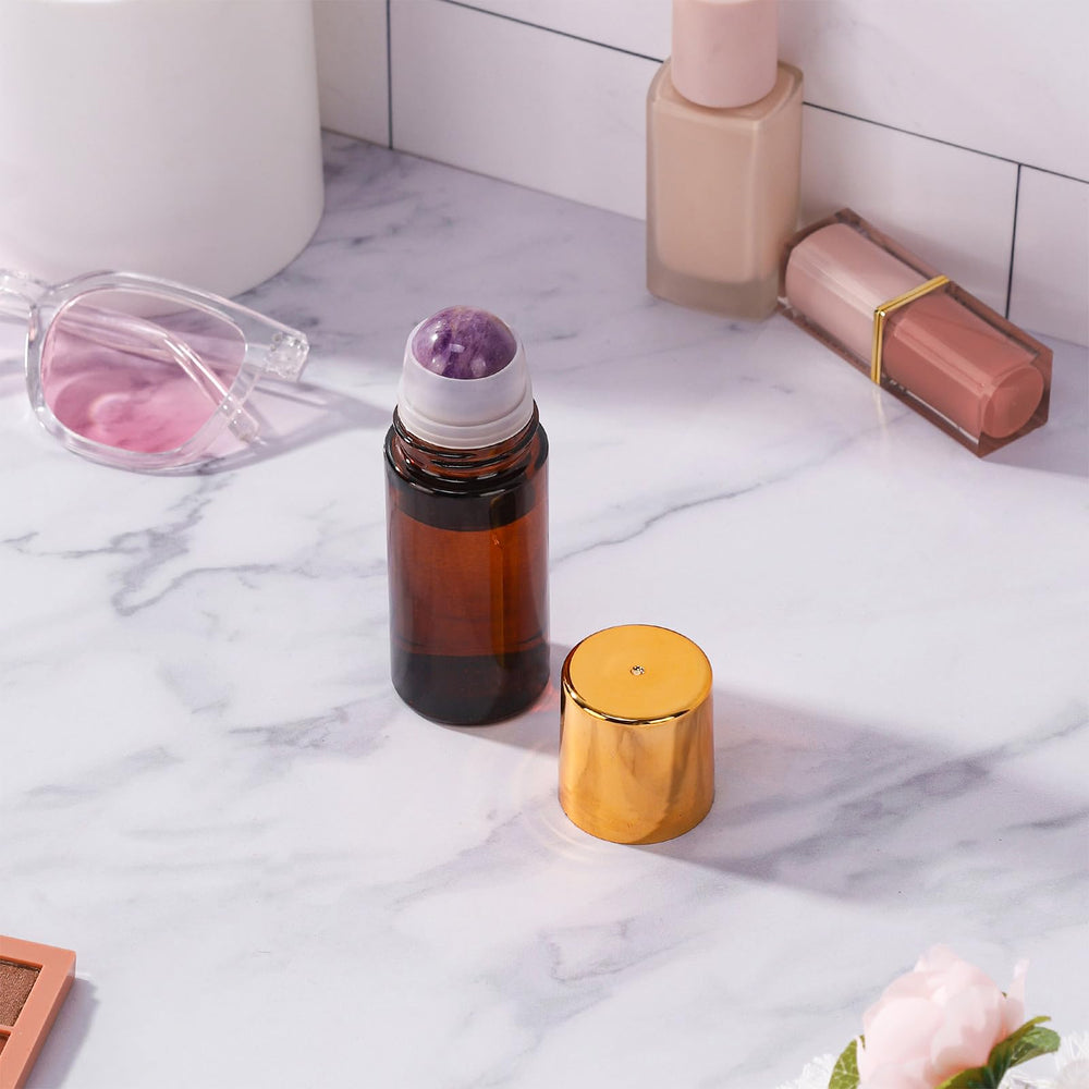 RAMFIYN amber glass roll-on bottle with the purple crystal rollerball in use
