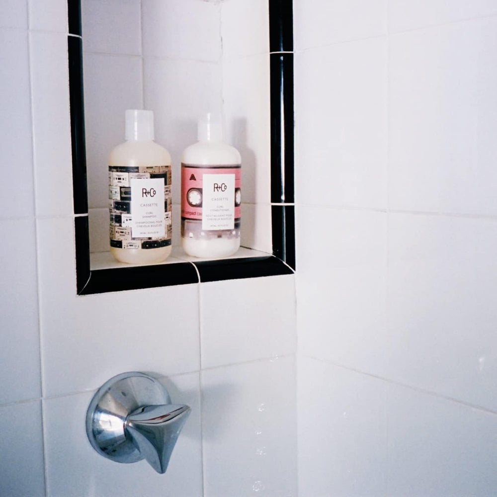 R+Co Cassette Curl Conditioner close-up shows smoothing for frizz-free shine.