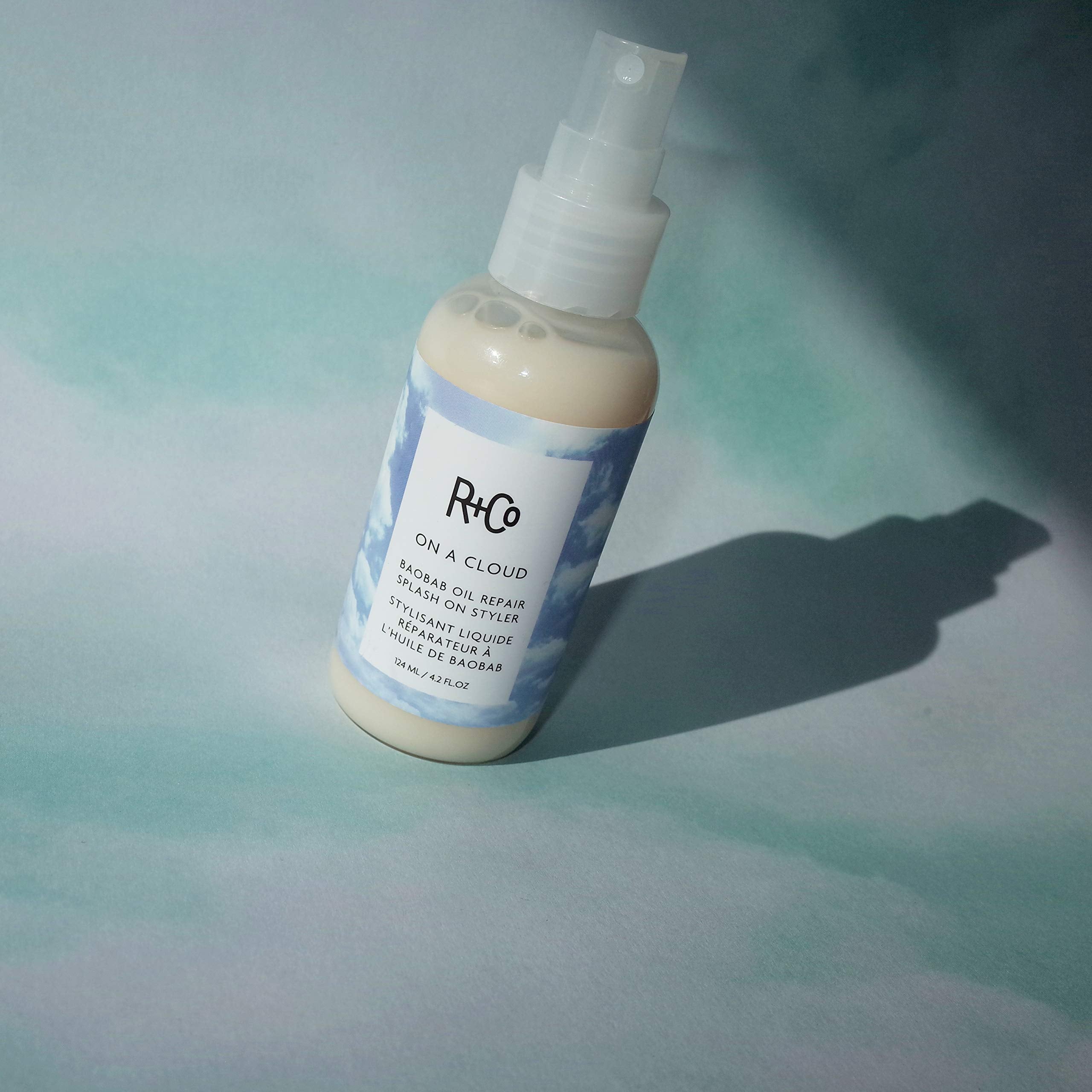 R+Co On A Cloud Baobab Oil Repair Splash dispense shows easy application for smooth, frizz-free styling.