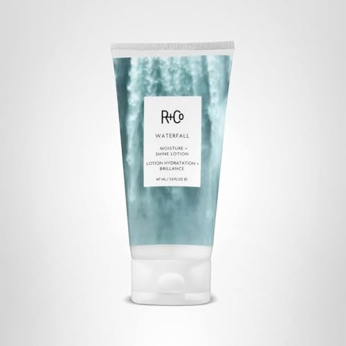 R+Co Waterfall Lotion surrounded by flowers emphasizing natural beauty.
