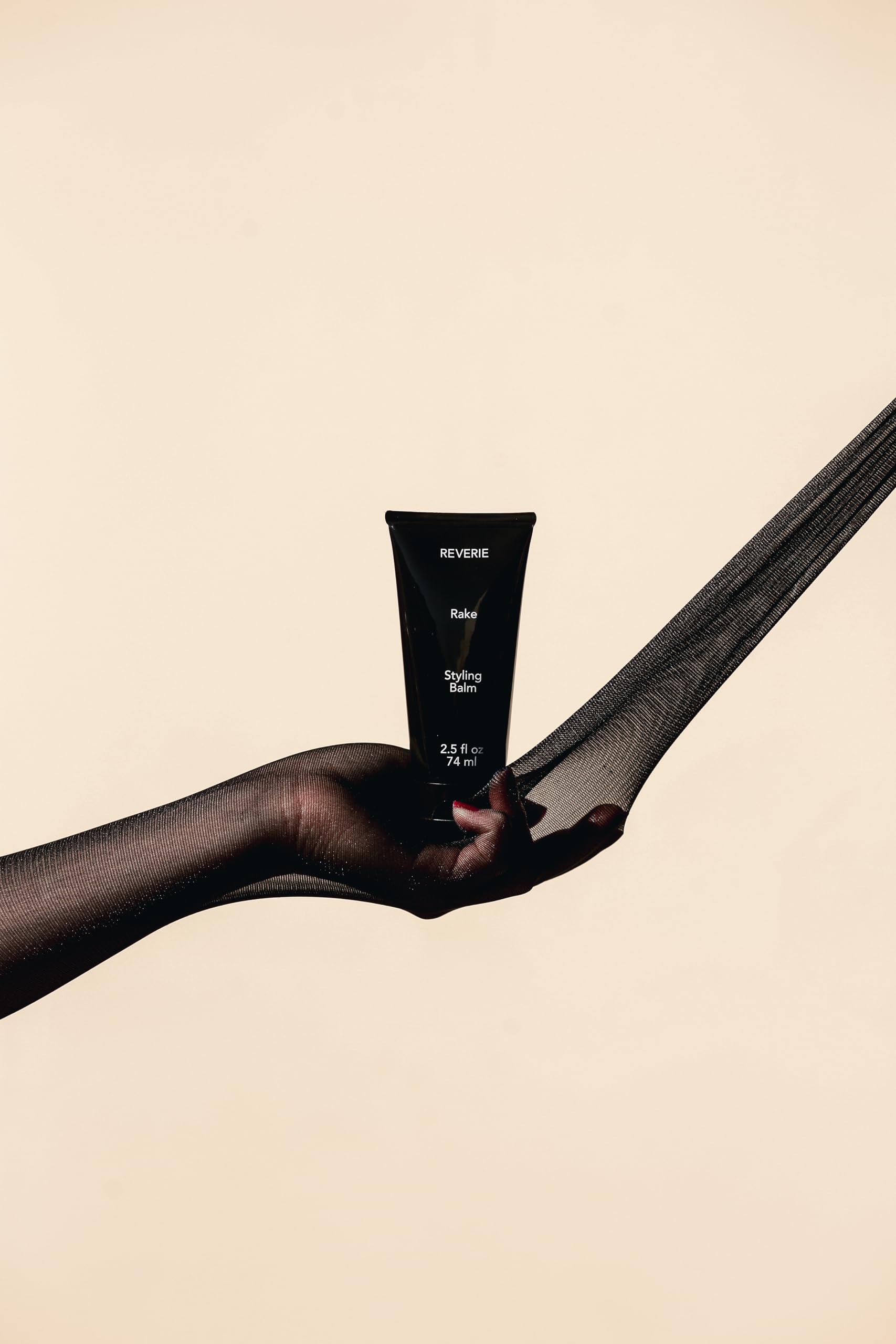 Hands applying REVERIE balm using rake technique for curl definition