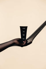 Hands applying REVERIE balm using rake technique for curl definition