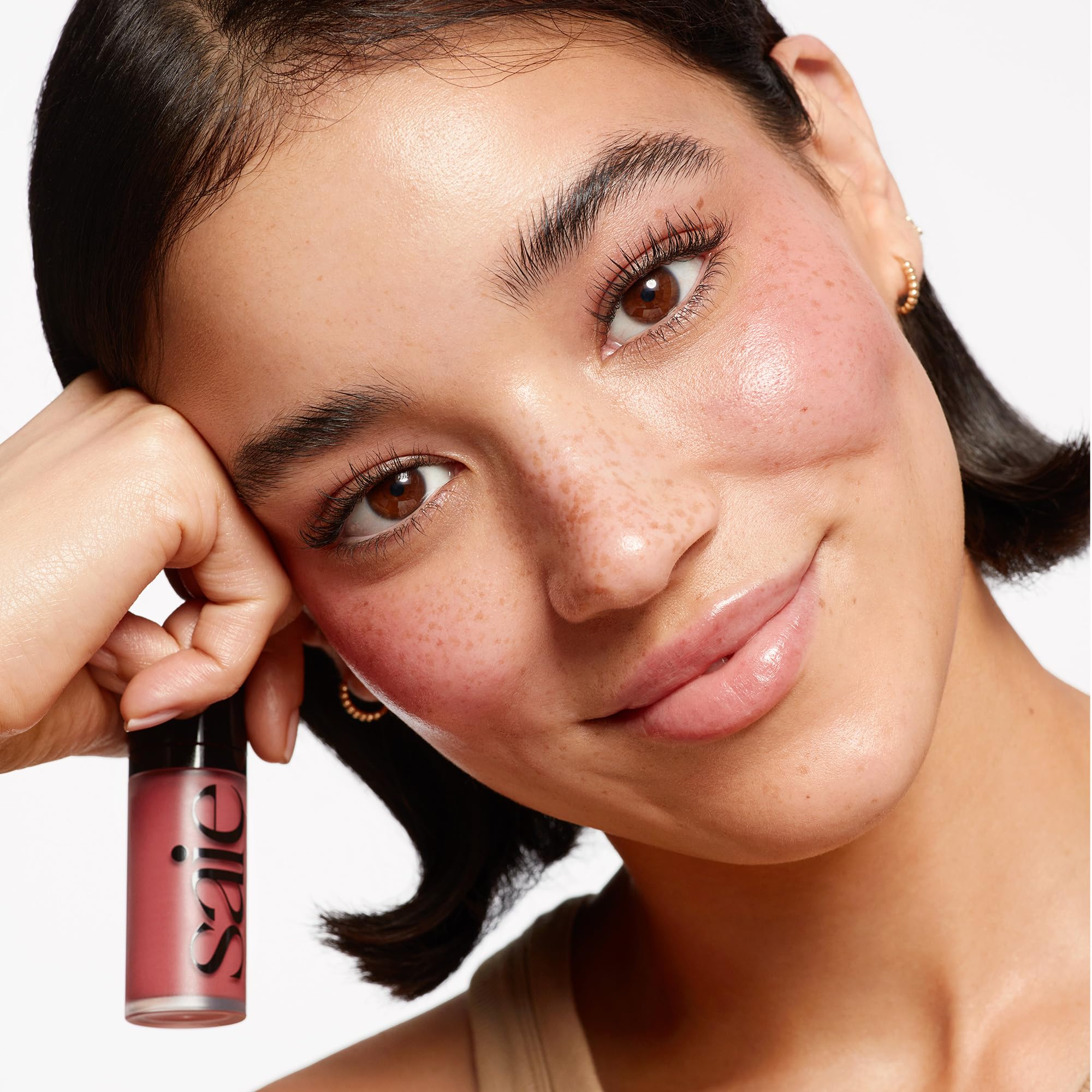 Saie Dew Liquid Blush close-up-texture emphasizes creamy, blendable formula for seamless skin.