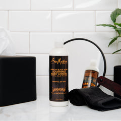 Hands applying SheaMoisture lotion to damp skin for better moisture retention.