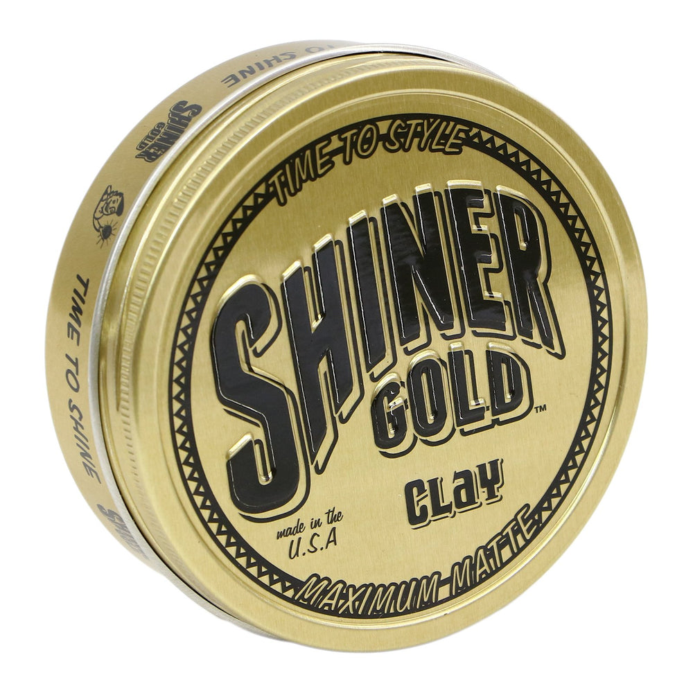 Shiner Gold Clay Pomade bottle closeup showcasing strong hold and matte finish for styling control.