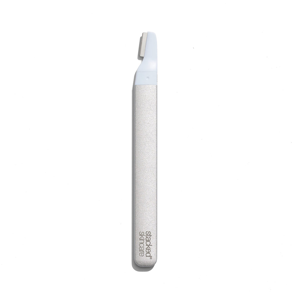 StackedSkincare dermaplaning tool refill in hand for quick, hygienic blade replacement.