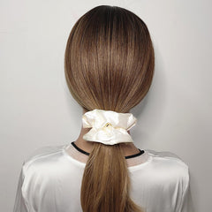 Close-up of Sufermoe satin silk scrunchies showing soft texture and gloss.