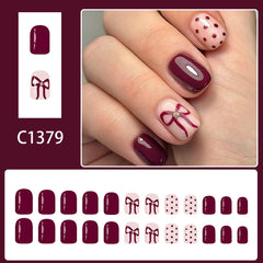 SYPAFG burgundy nails polka dot bow design close-up showcasing glossy, reusable press-on quality.