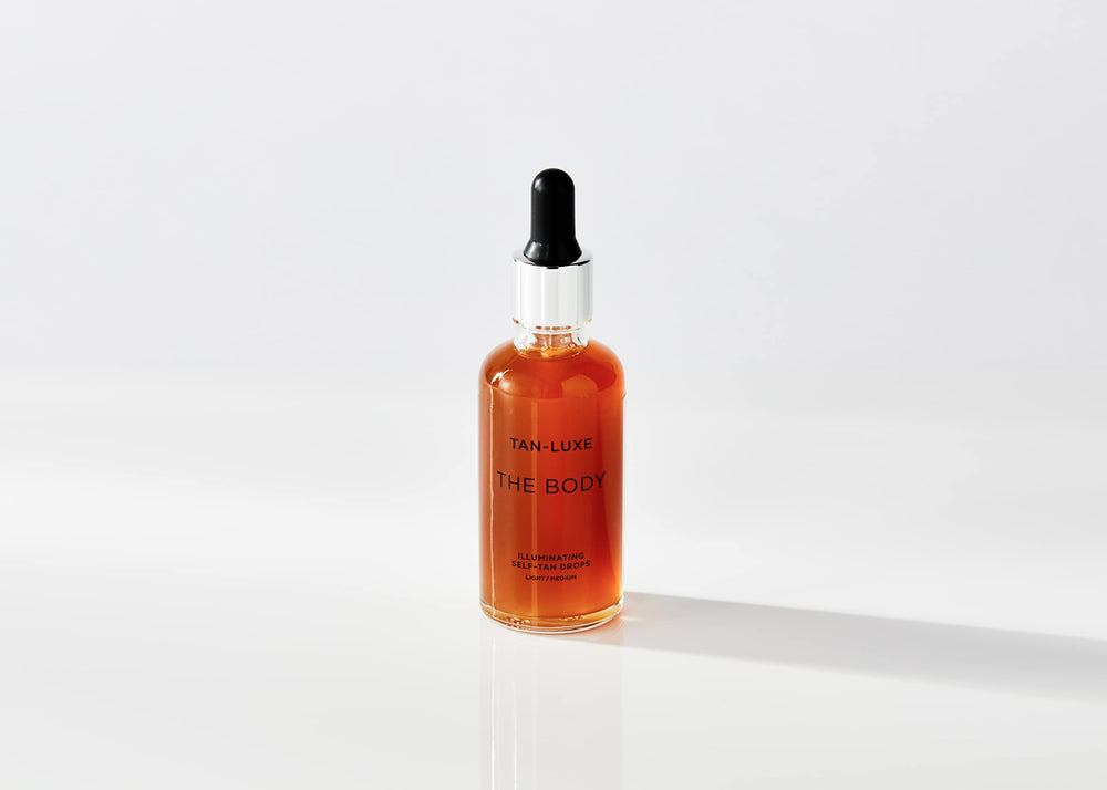Tan-Luxe The Body Illuminating Drops dropper in use for customizable tan shade