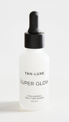 Close-up of TAN-LUXE Super Glow dropper applying serum for daily hydration and glow.