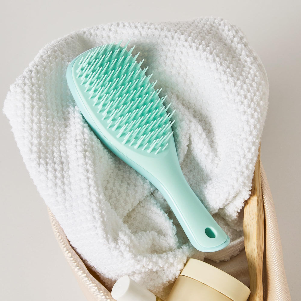 Tangle Teezer mint brush in gym bag ready for travel.