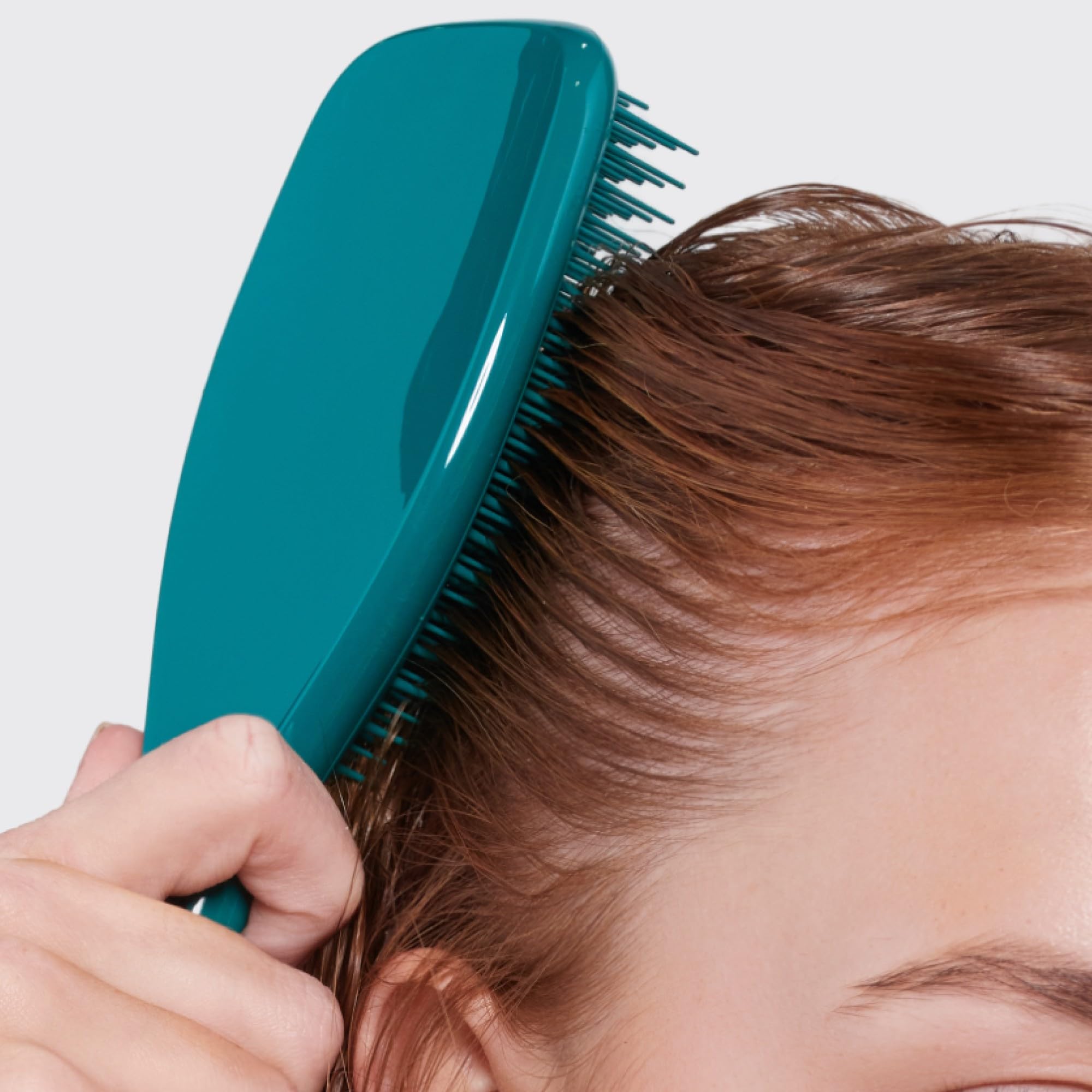 Tangle Teezer detangler evenly distributes conditioner through hair for smoother results.