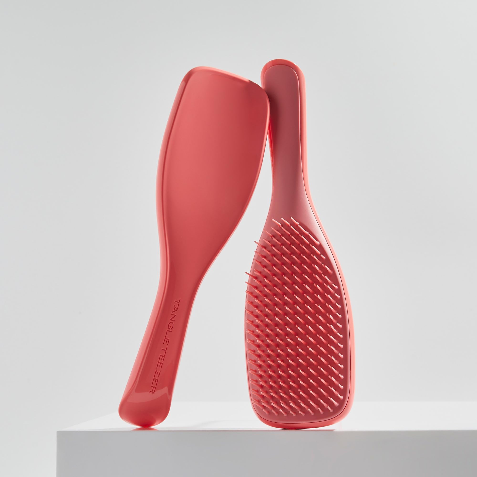 Tangle Teezer Ultimate Detangler held in hand highlights reduced detangling time.