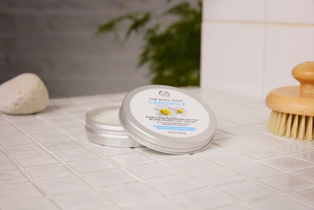 The Body Shop Camomile Sumptuous Cleansing Butter scoop application shows creamy texture for makeup removal.
