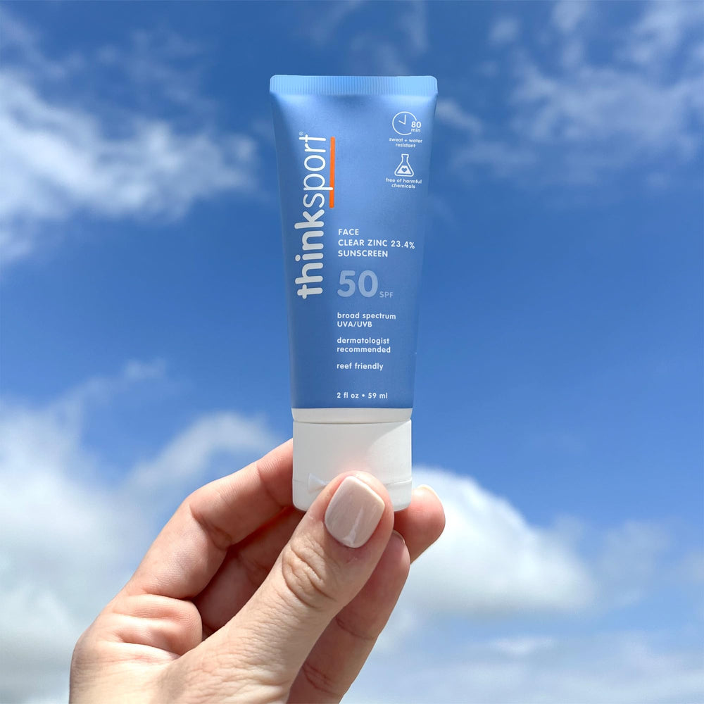 Thinksport reef-safe mineral formula bottle with natural shade reflection on beach backdrop