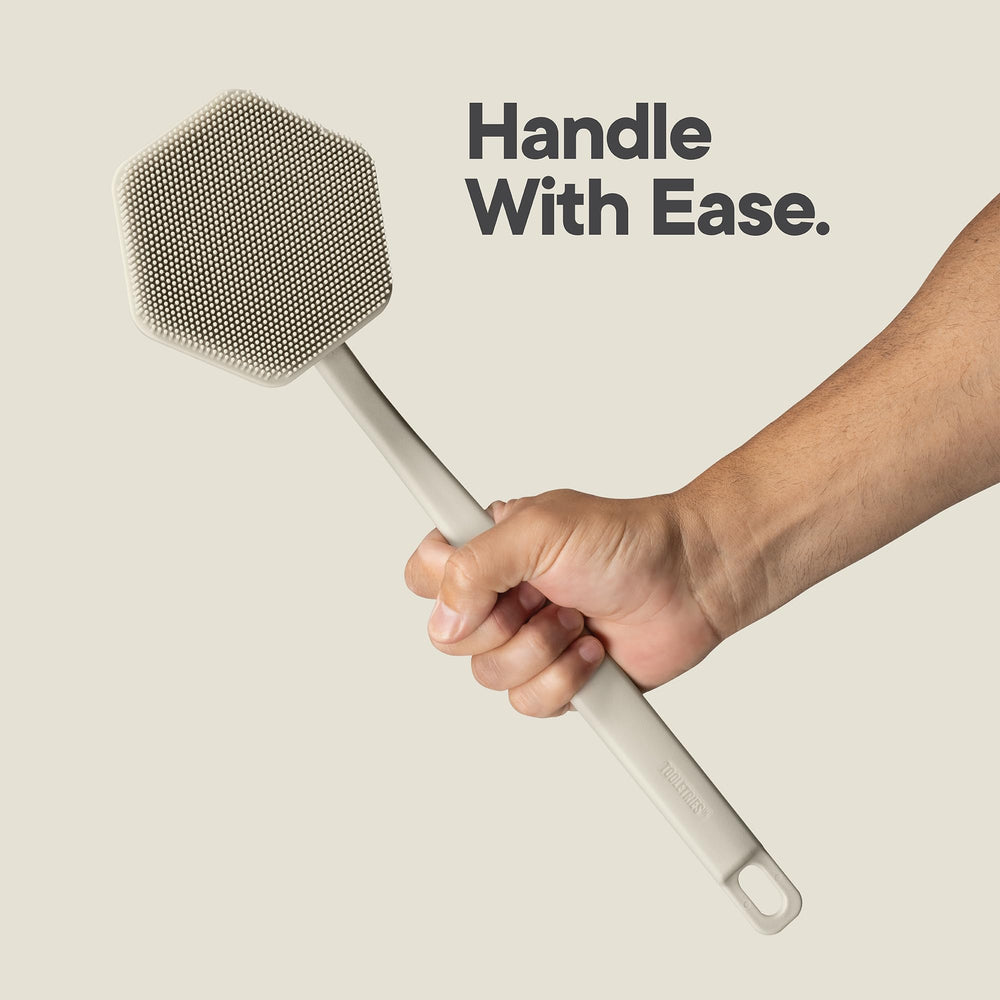 TOOLETRIES back-scrubber attached hook sticks securely on smooth surfaces for hygienic storage.