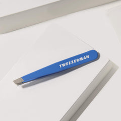 Tweezerman Mini Slant travel tweezers in Bahama Blue; ideal for brow shaping on the go.