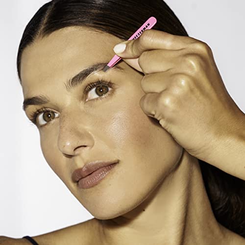 Tweezerman travel tweezers neon pink in hand demonstrates compact portability for on-the-go grooming