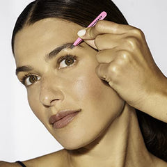 Tweezerman travel tweezers neon pink in hand demonstrates compact portability for on-the-go grooming