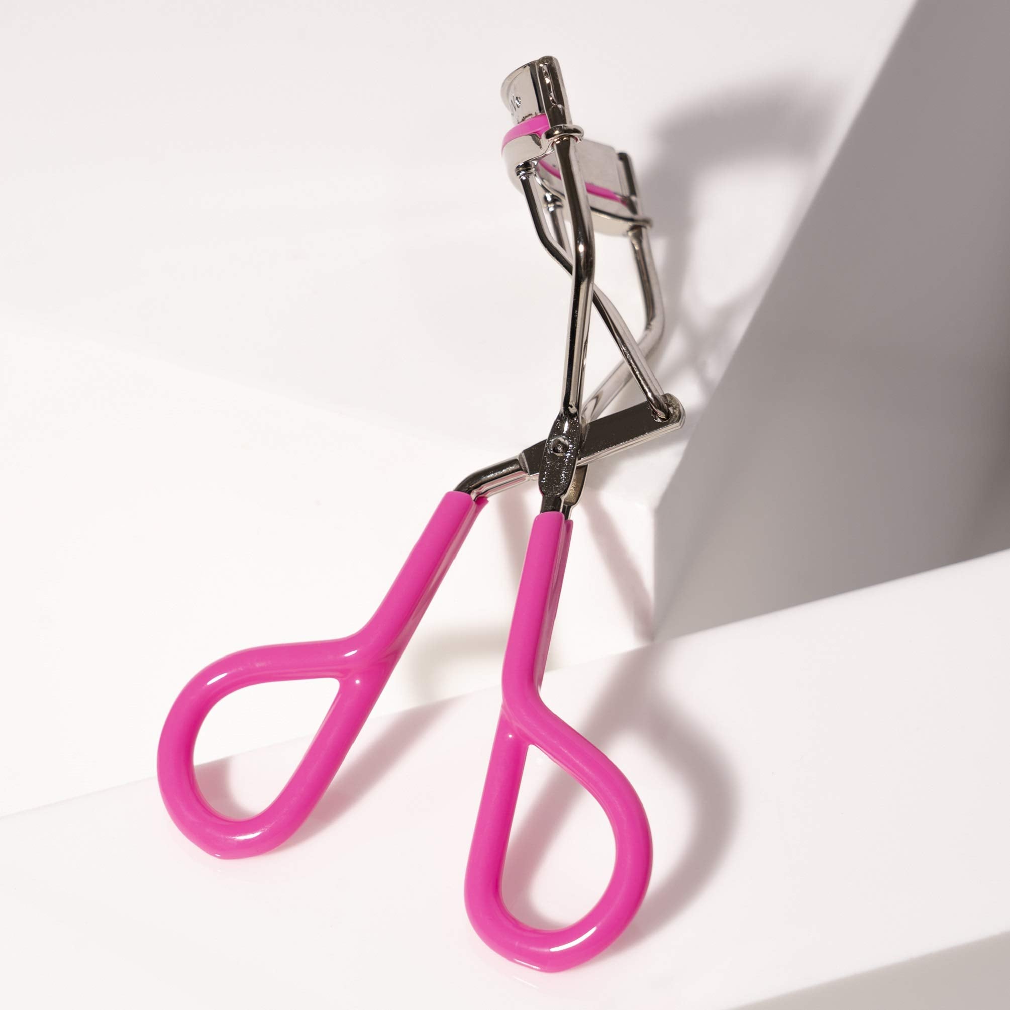 Tweezerman Neon Pink eyelash curler silicone pads providing smooth opening and closing.