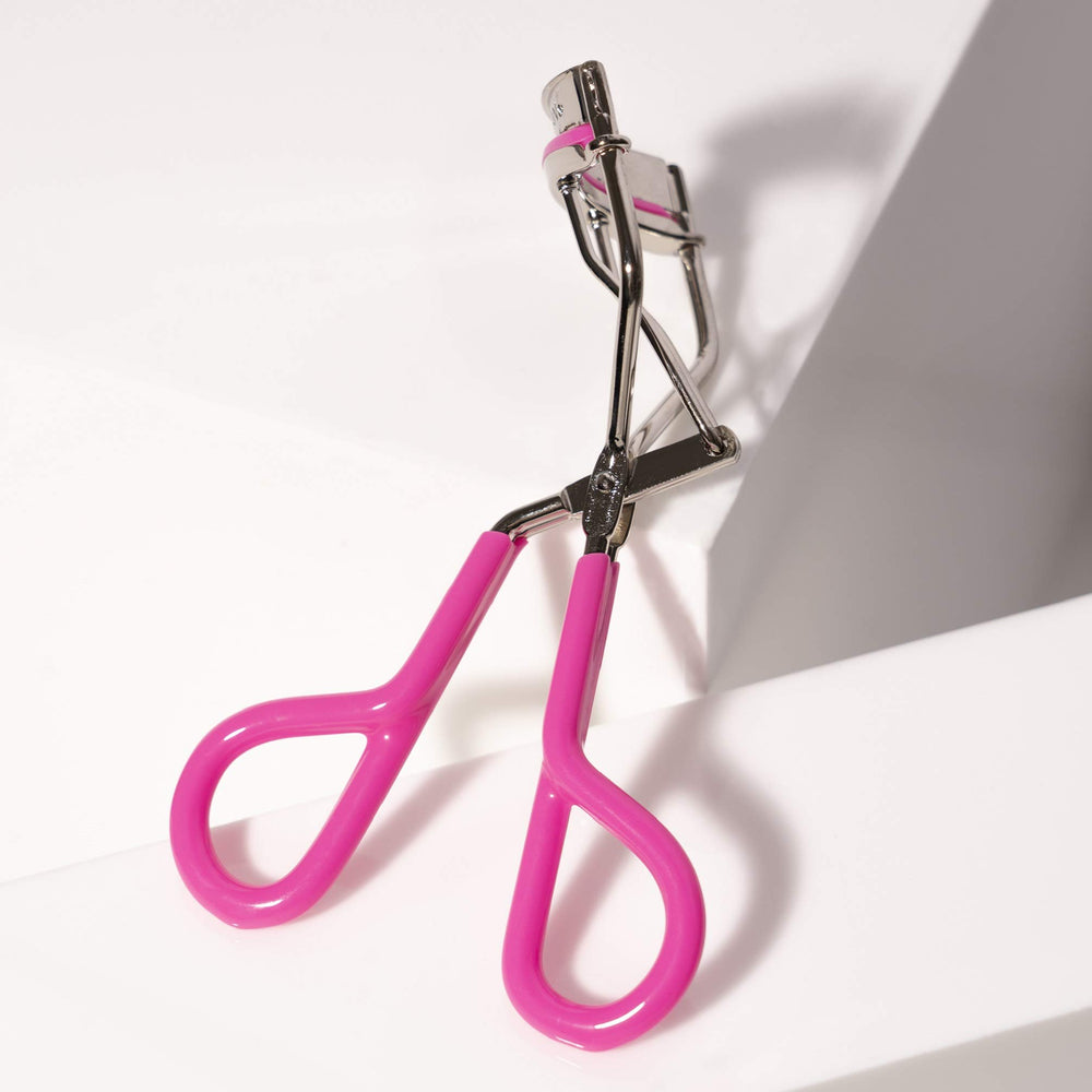 Tweezerman Neon Pink eyelash curler silicone pads providing smooth opening and closing.