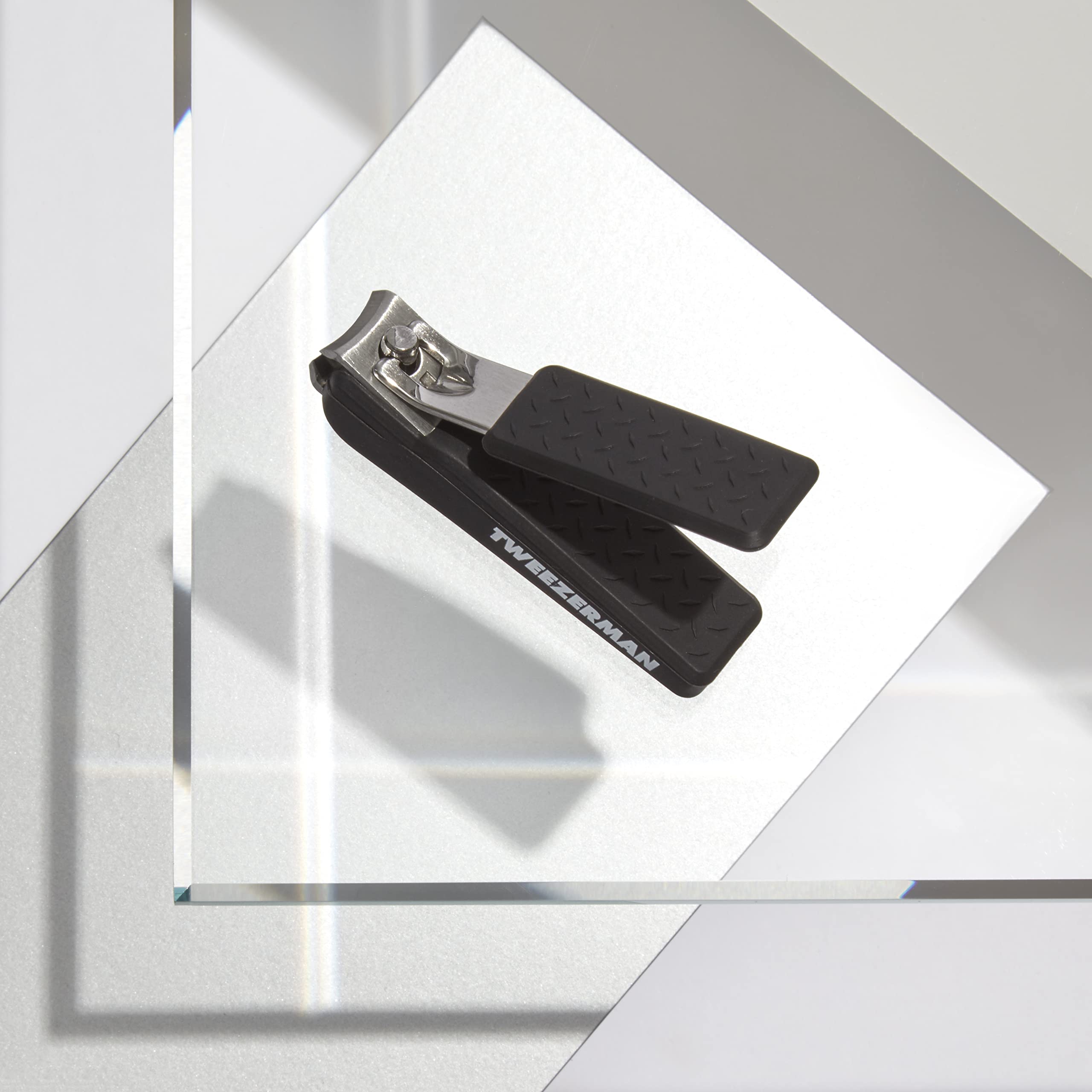 Tweezerman Precision Grip Fingernail Clipper in hand showing non-slip textured handle for tough nails