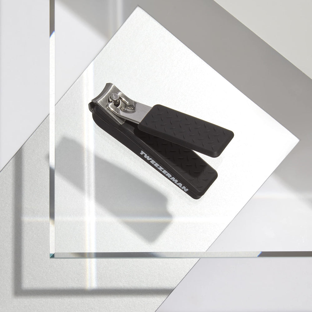 Tweezerman Precision Grip Fingernail Clipper in hand showing non-slip textured handle for tough nails