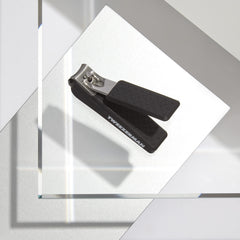 Tweezerman Precision Grip Fingernail Clipper in hand showing non-slip textured handle for tough nails